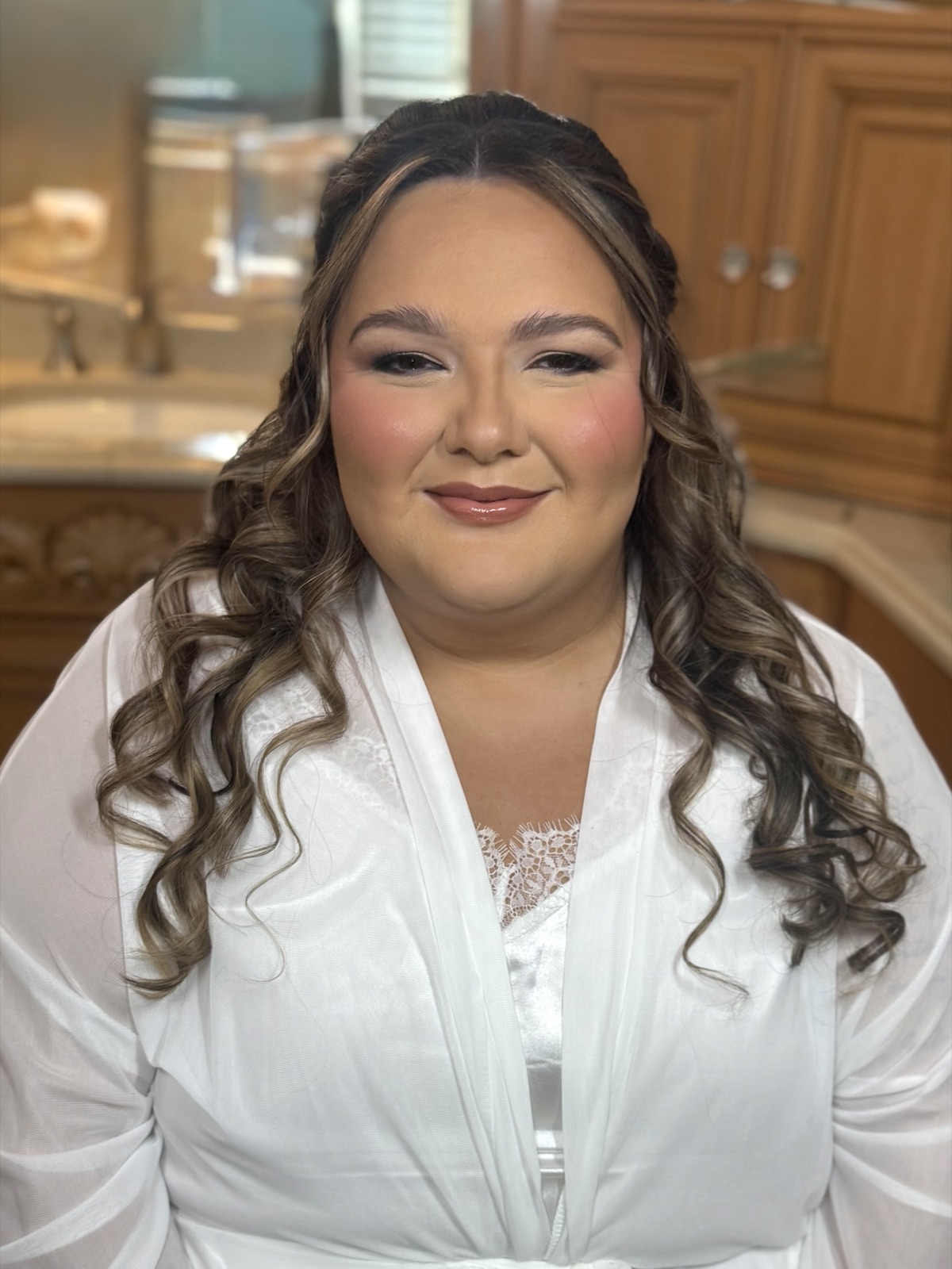 Bride in silk robe with soft curls, getting ready